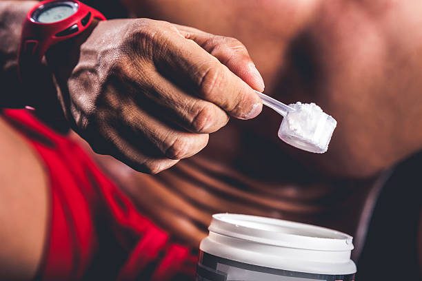 Man holding protein bottle after workout.